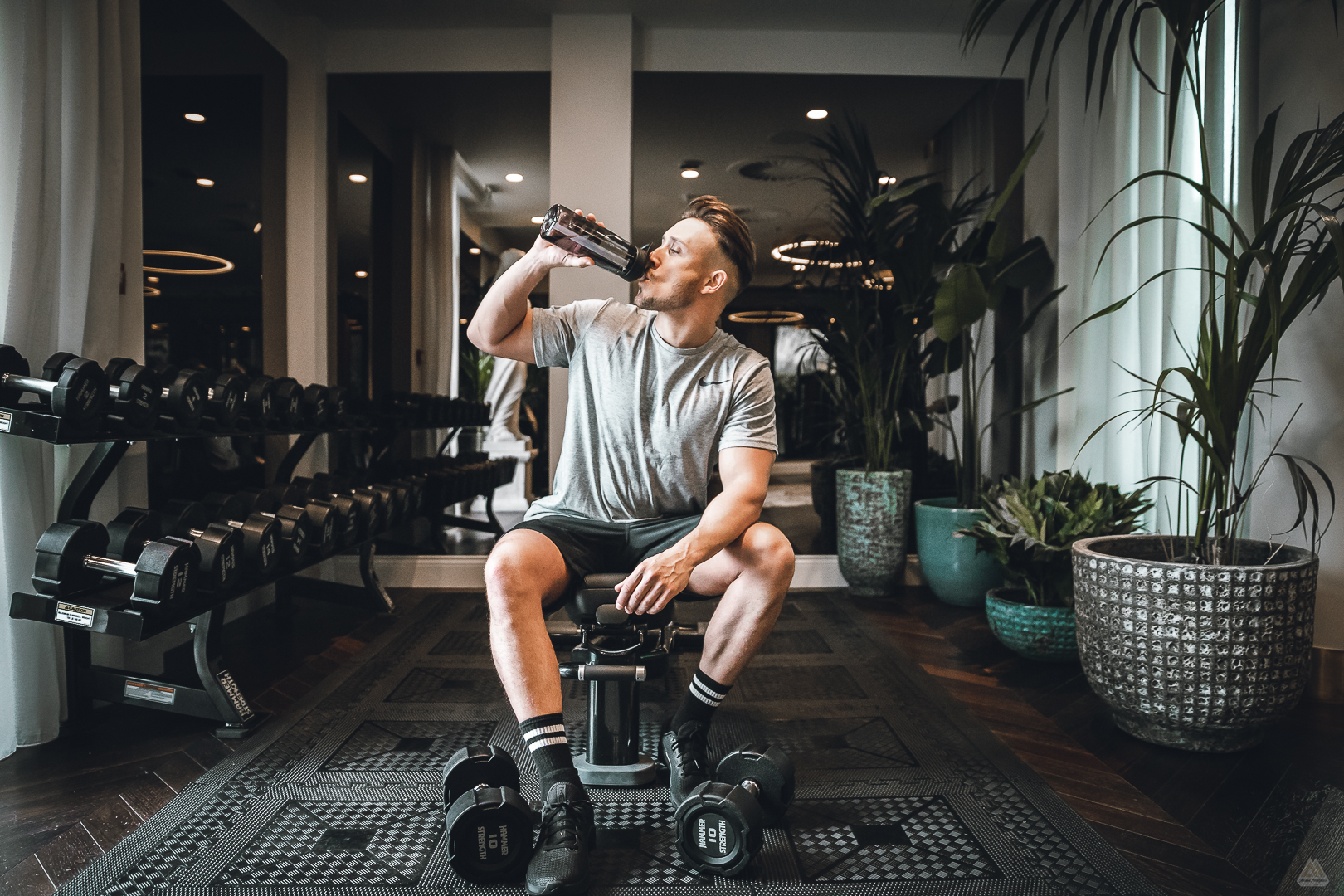Portrait of a young male drinking water after a workout in a gym