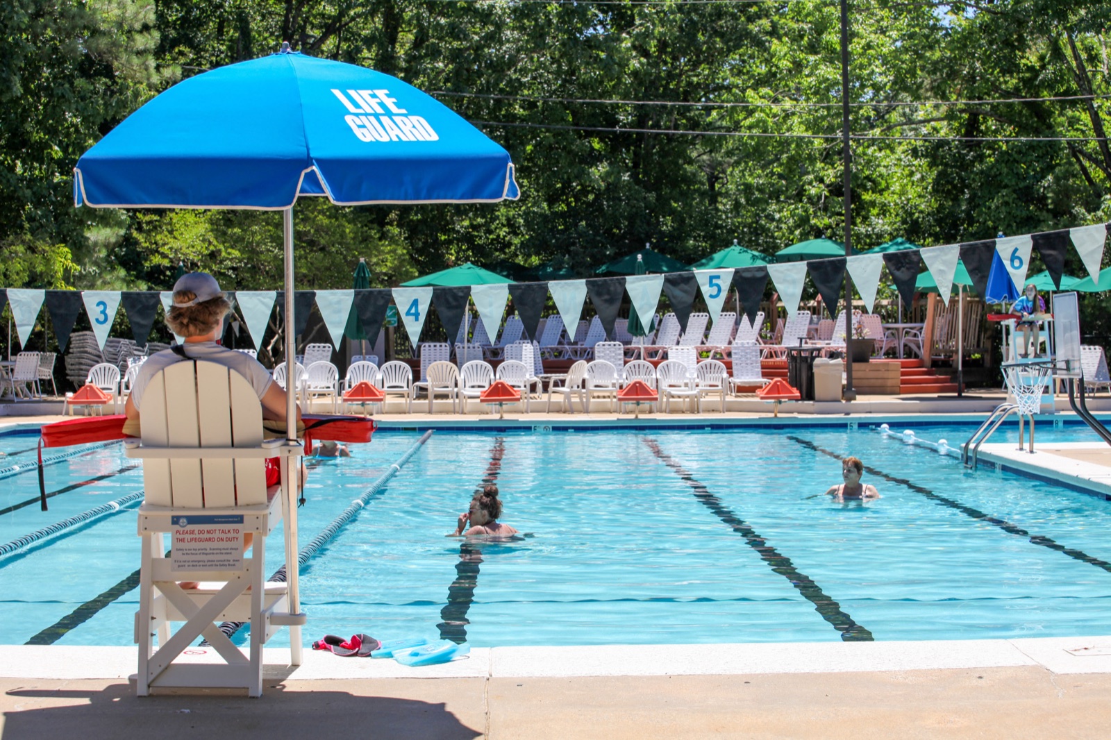 Lifeguard umbrella and chairs beside an outdoor campus pool