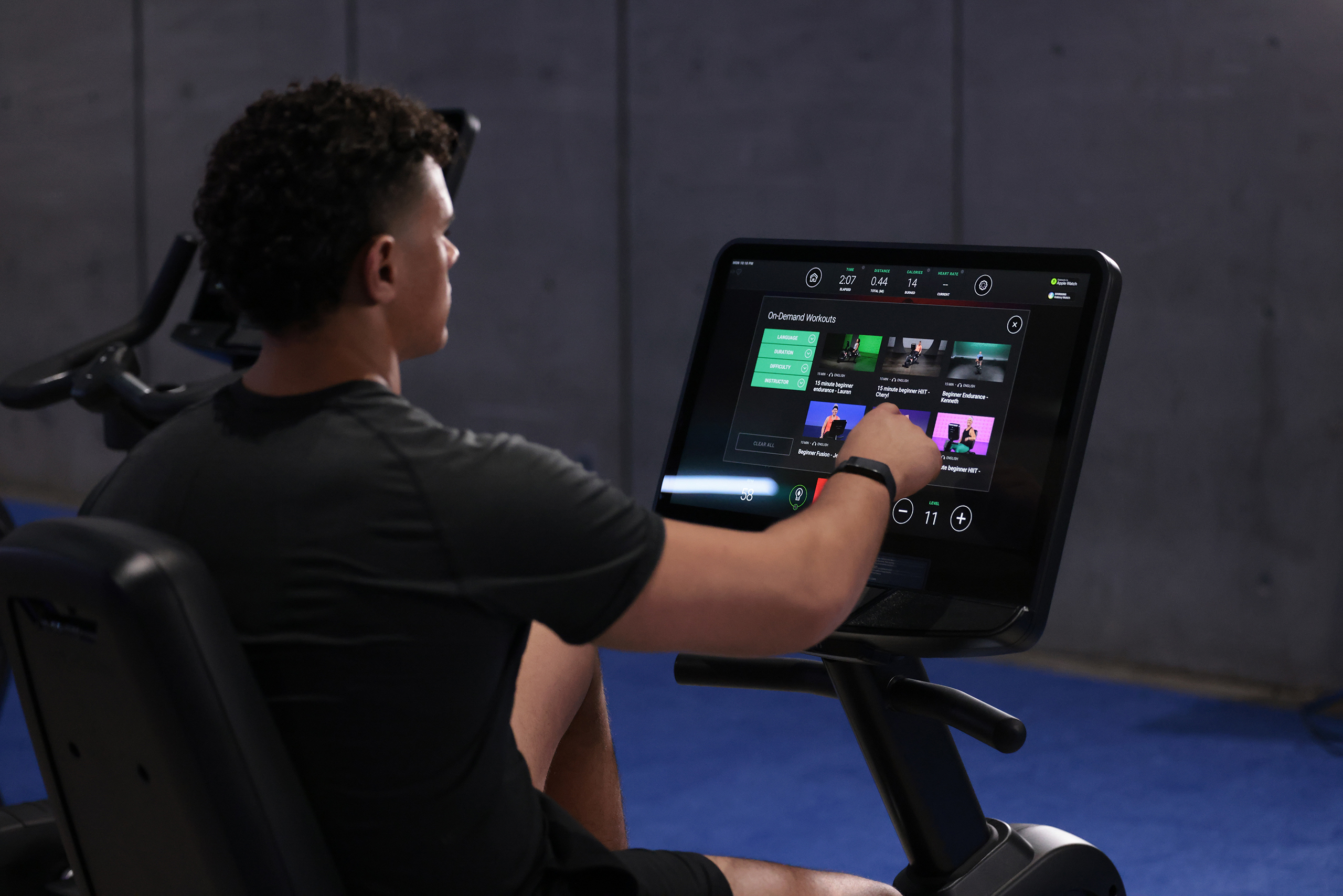 Male using the touch screen of an exercise bike