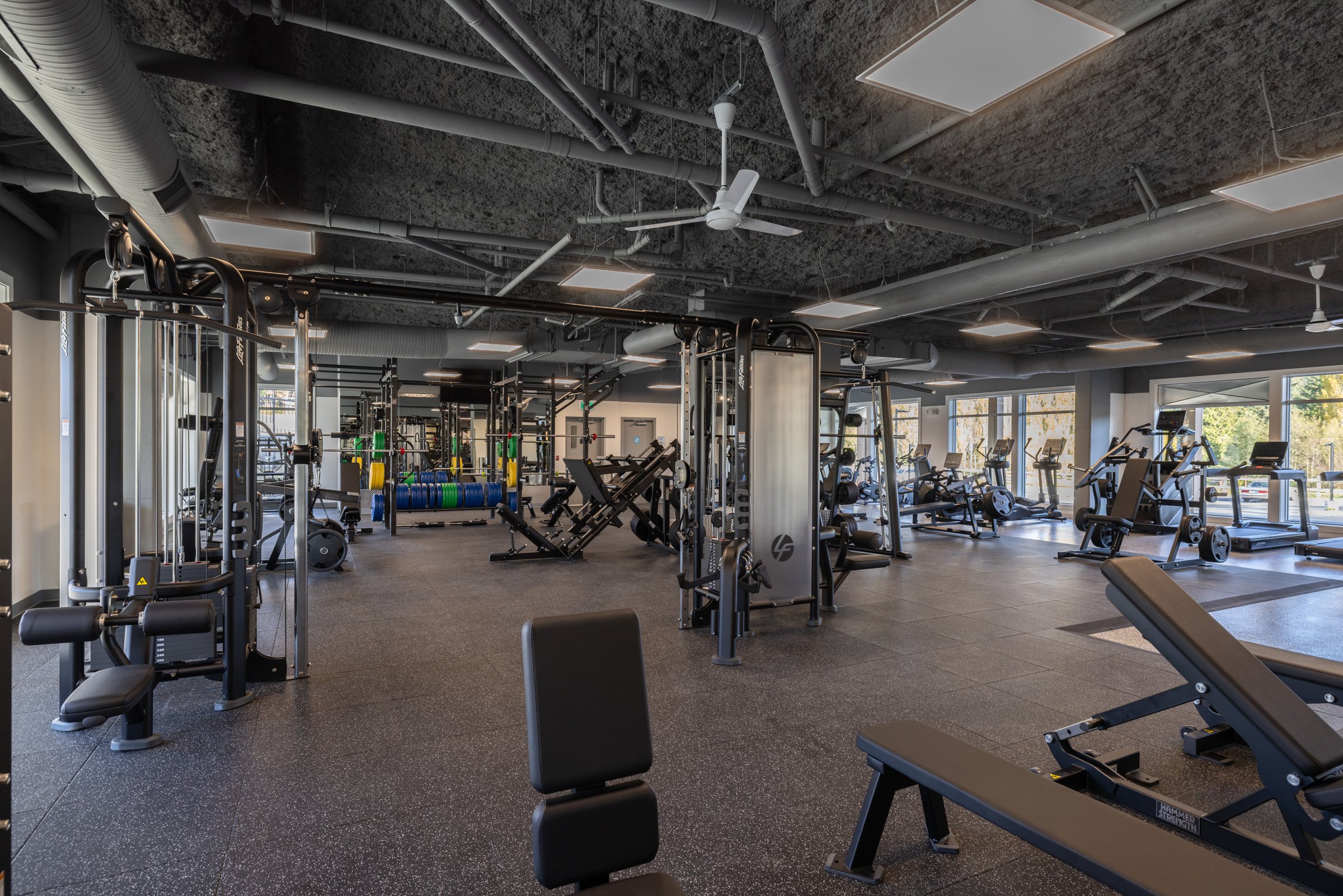 Fitness center with exposed ceiling, cable machines and strength equipment