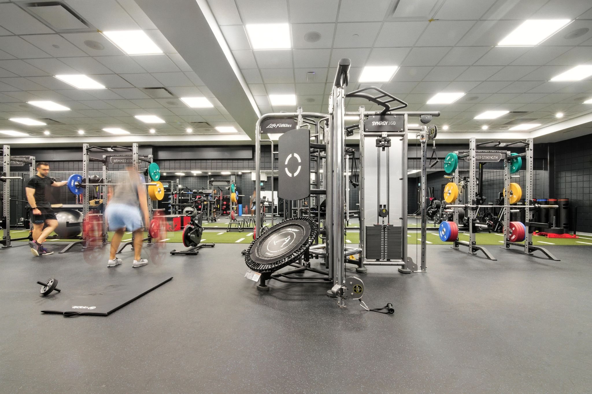 Strength training floor with cable machines beside floor-to-ceiling windows