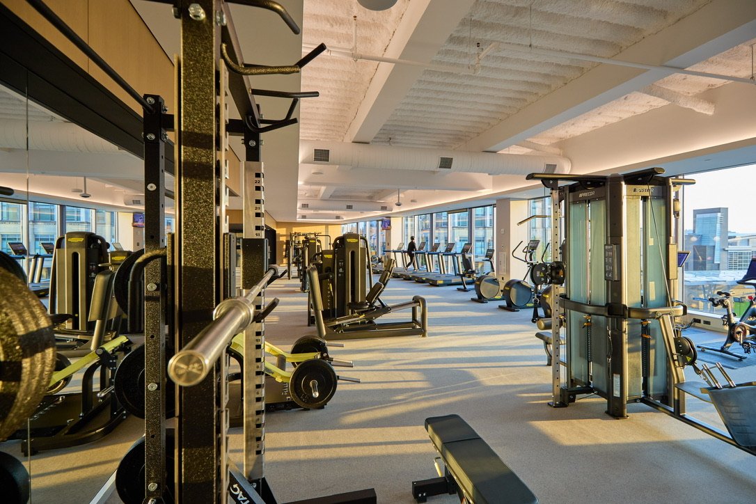 Weight training area with cable stations and mirrored walls