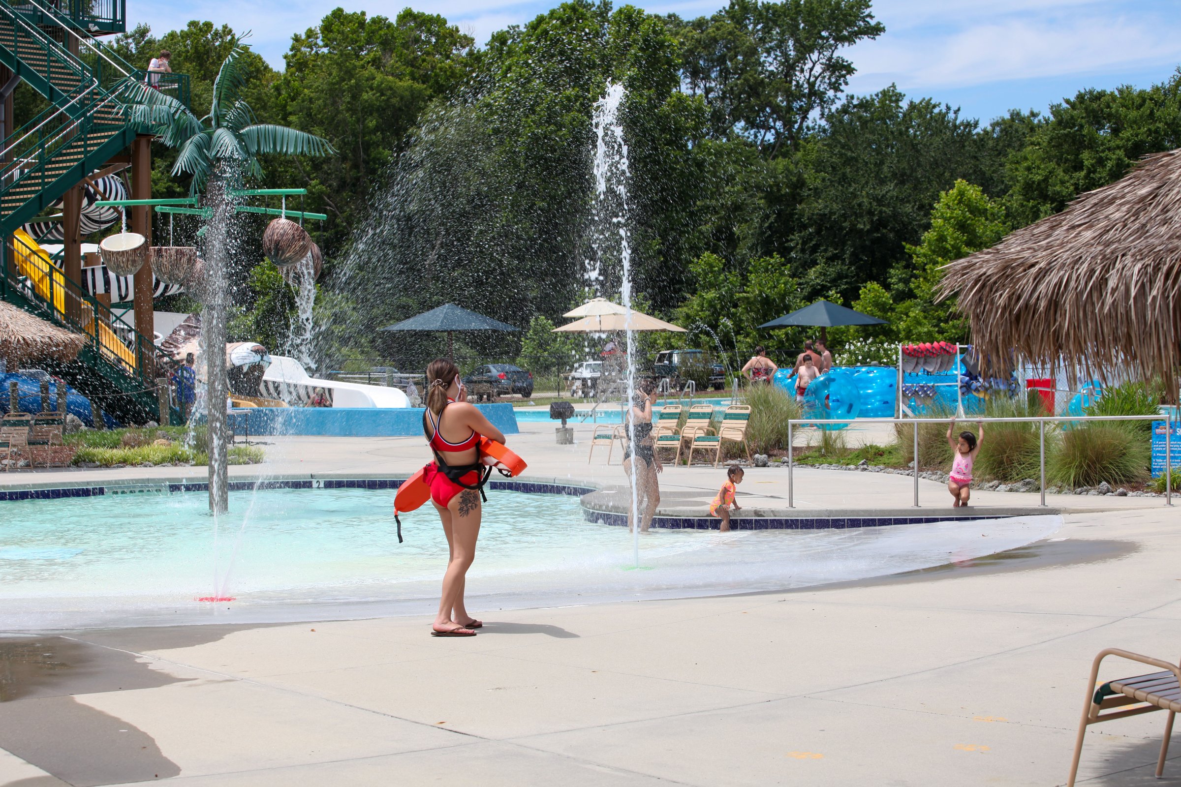 Children playing in a splash pad with water fountains