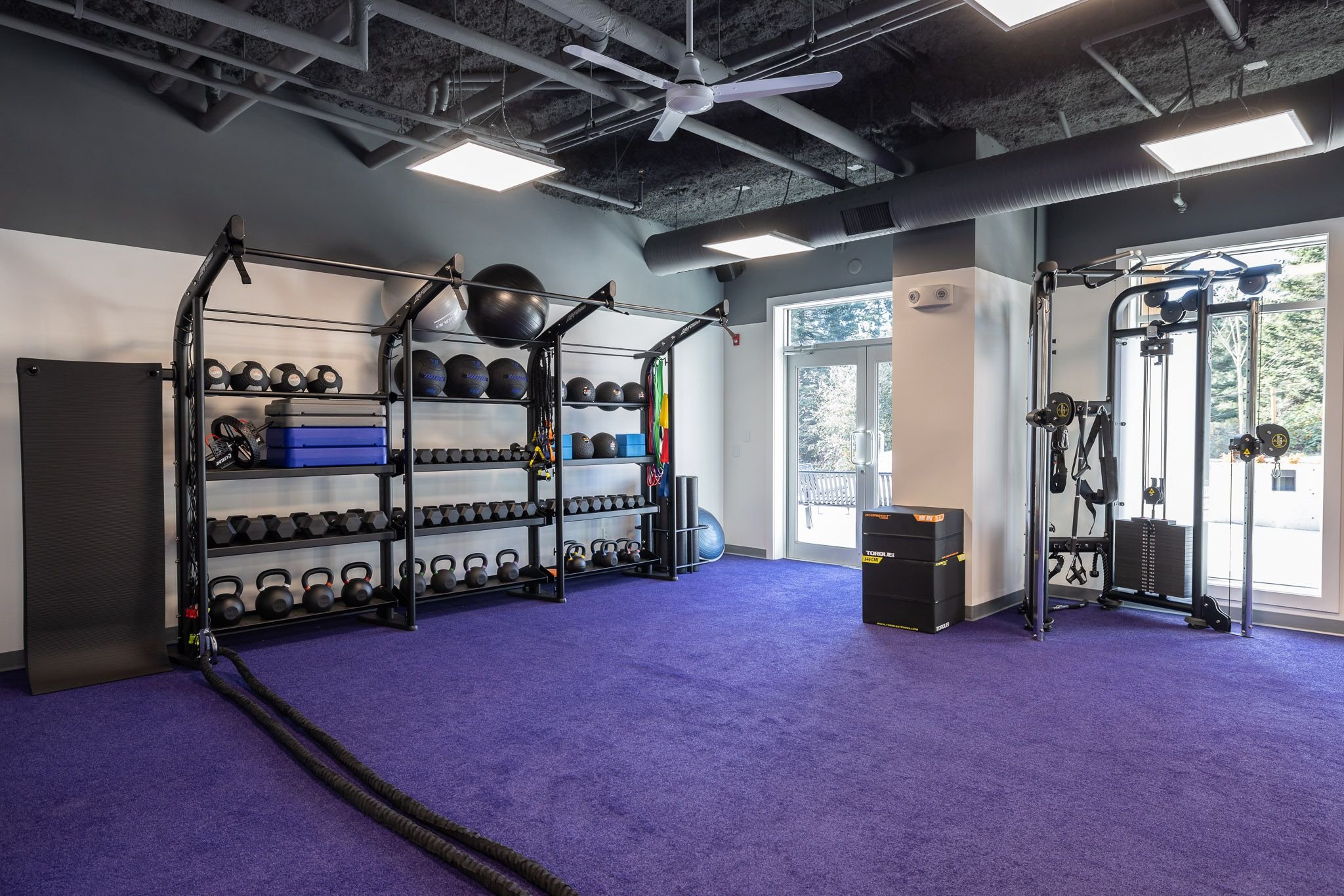 Functional training zone with kettlebells and battle ropes on purple turf