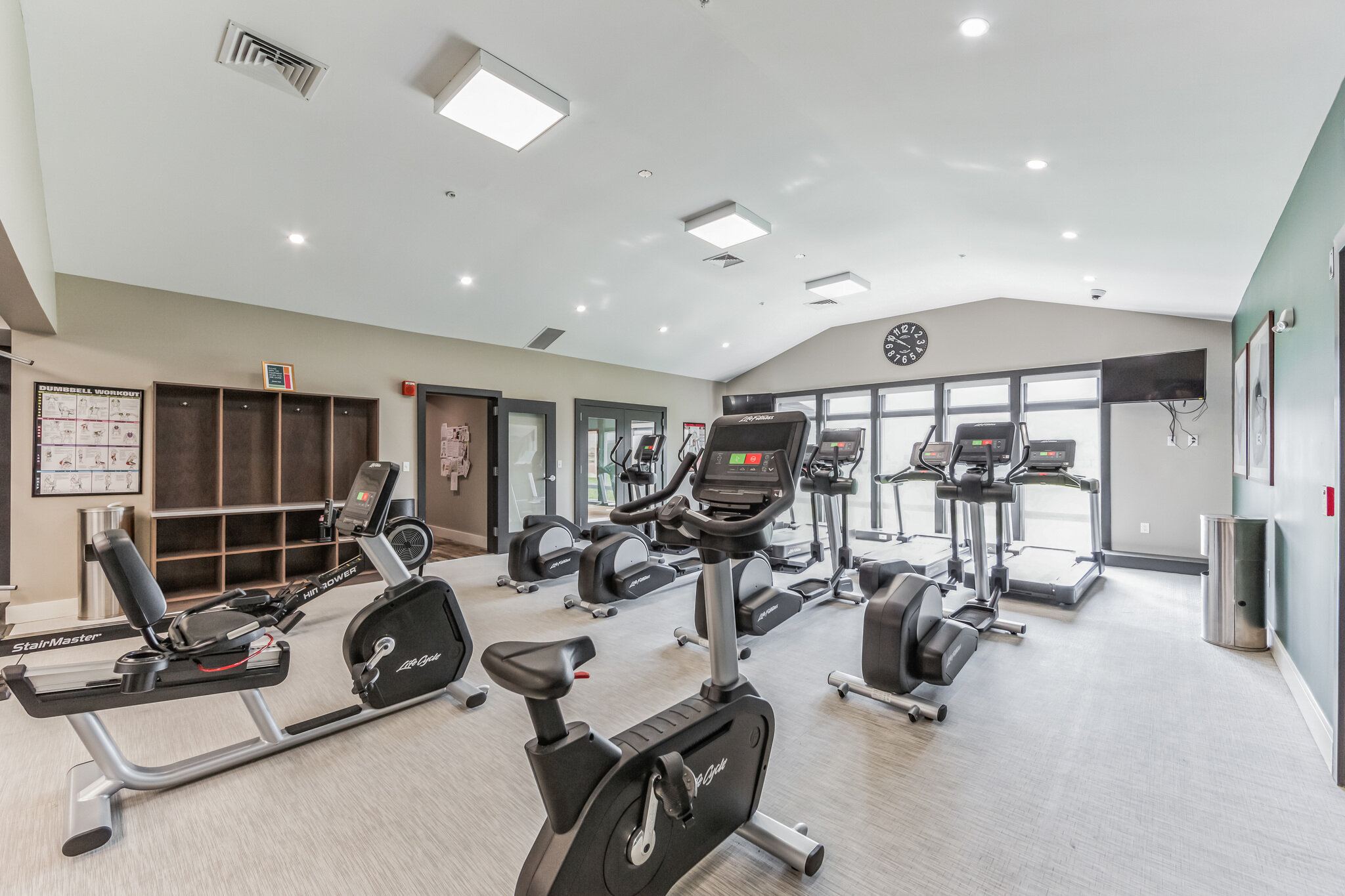 Community fitness room with recumbent bikes and elliptical trainers