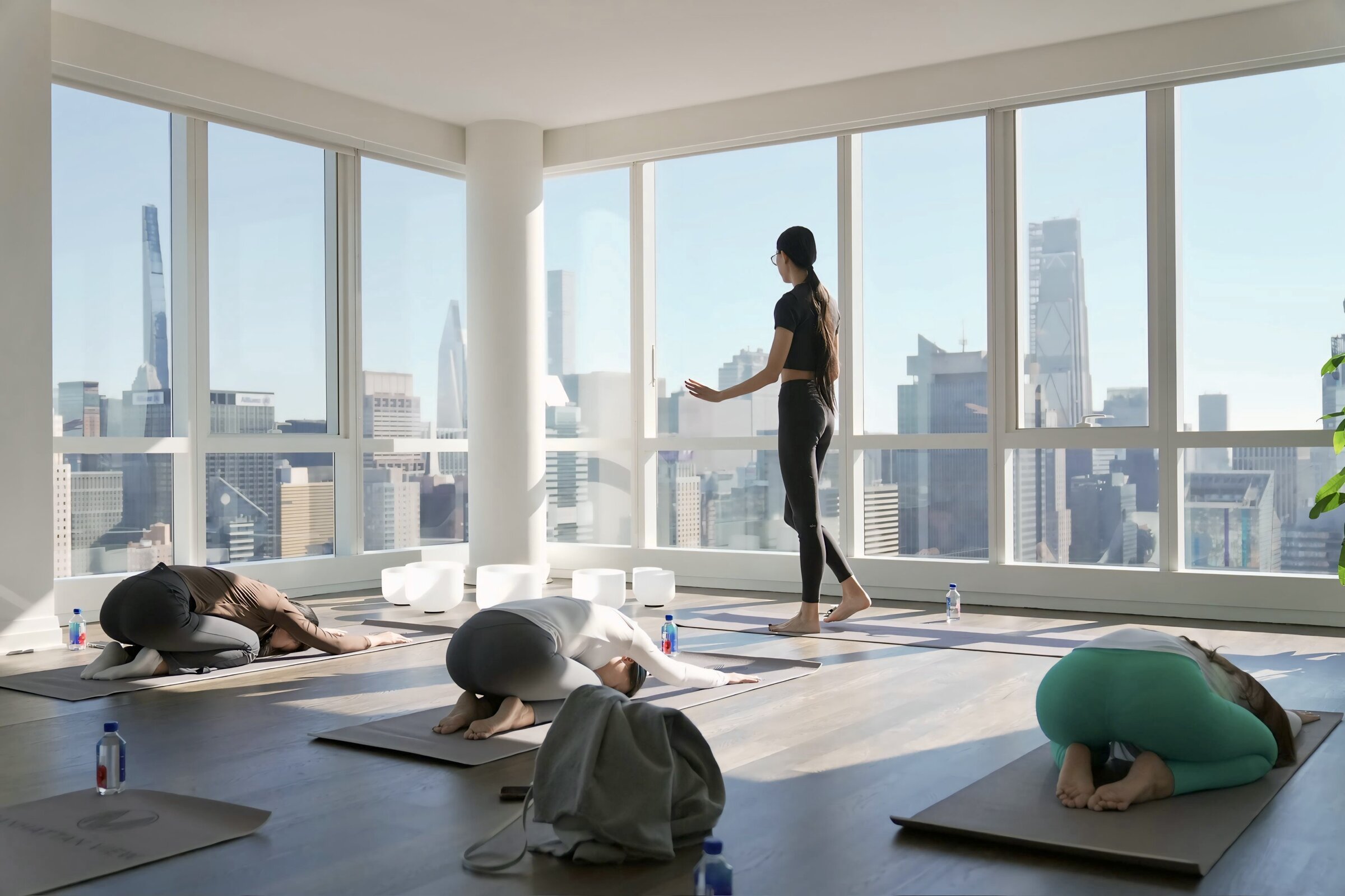 Stretching class in a corner studio with city skyline windows