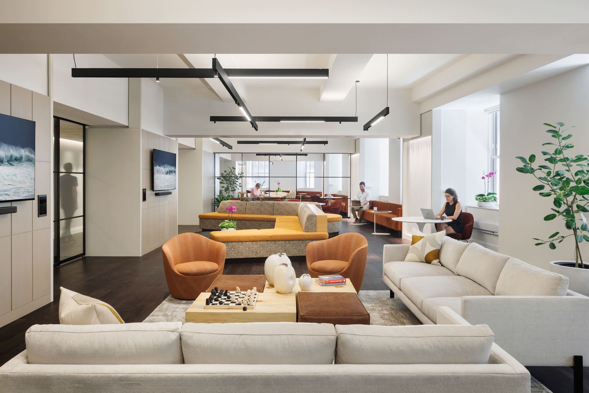 Coworking lounge with sofas, armchairs and soft pendant lighting