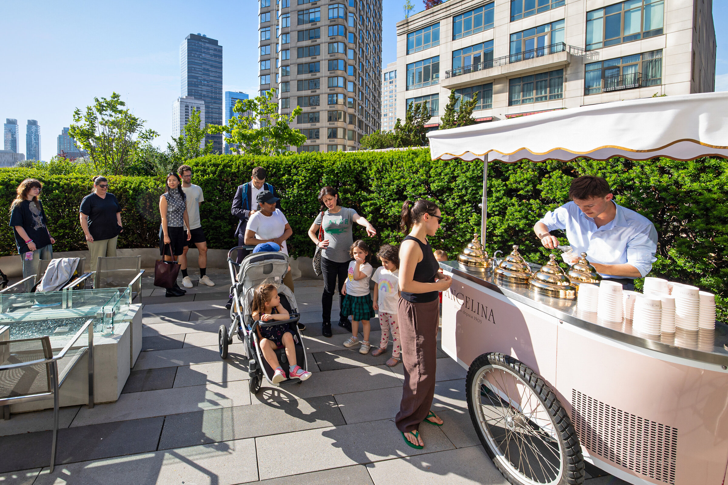 Outdoor terrace gathering with guests around an ice-cream cart