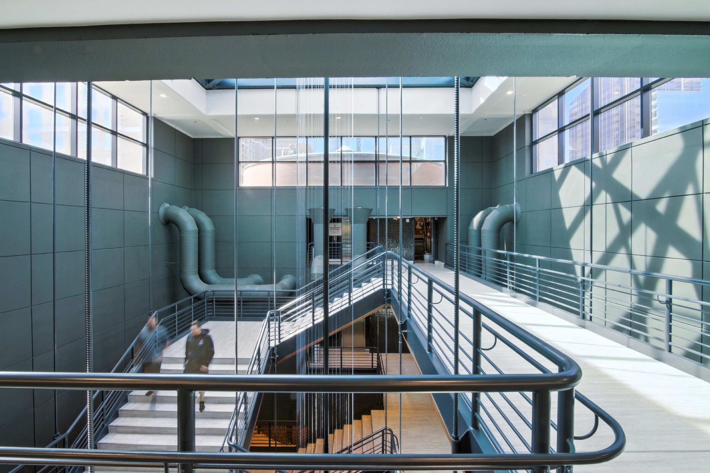 Industrial atrium with exposed ductwork and an open stairwell